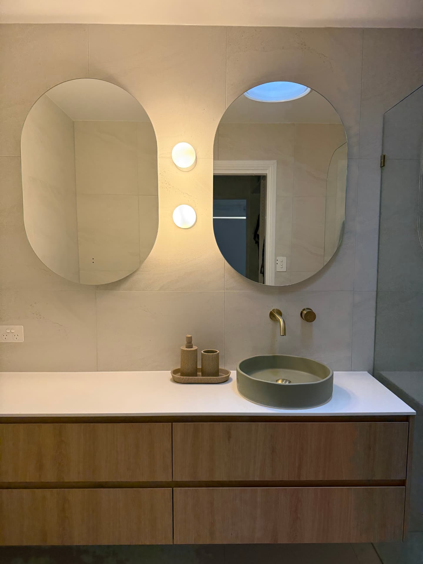 Tiled bathroom with a vanity and brass tapware