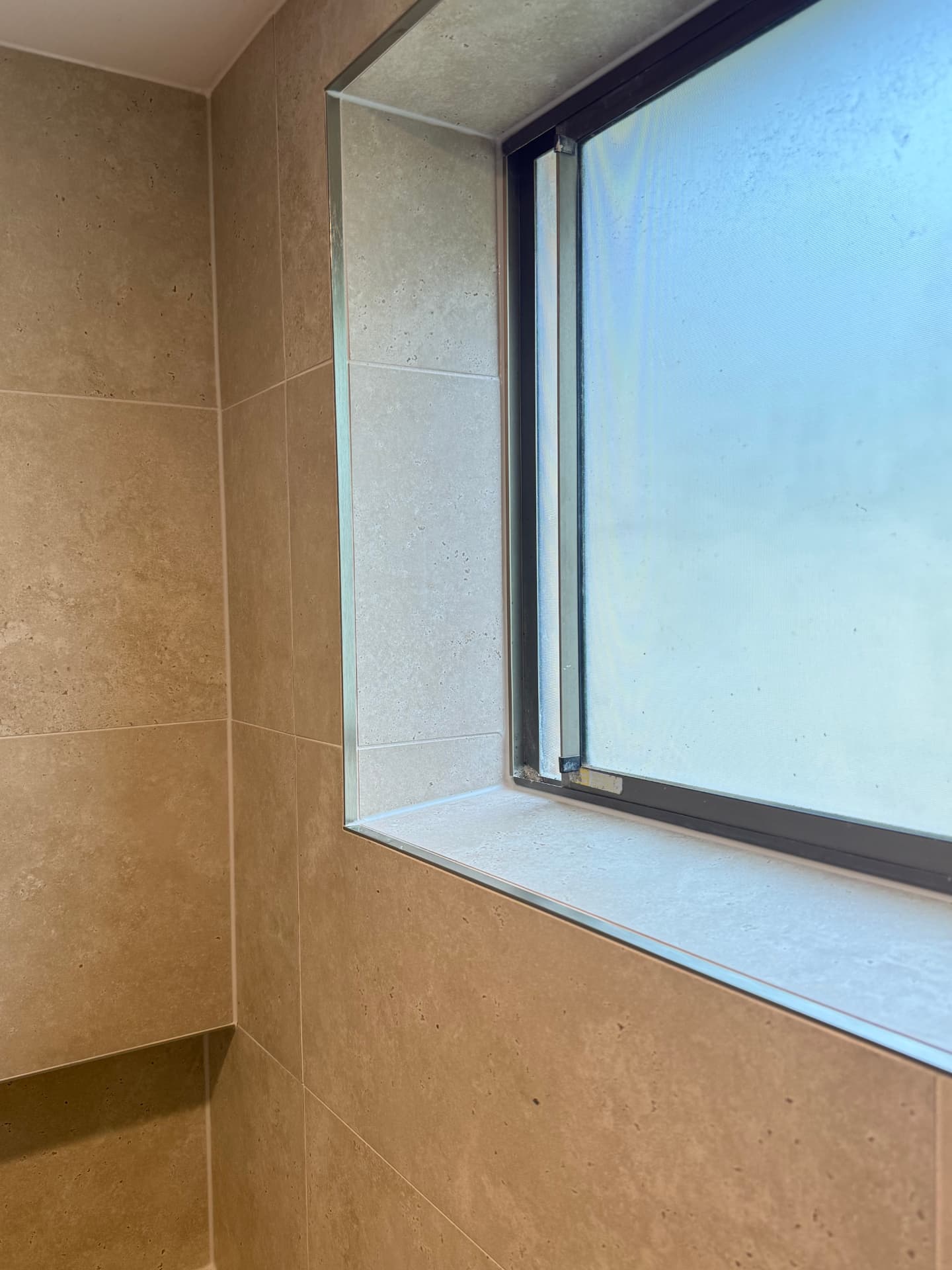 Close-up of a precisely tiled window reveal