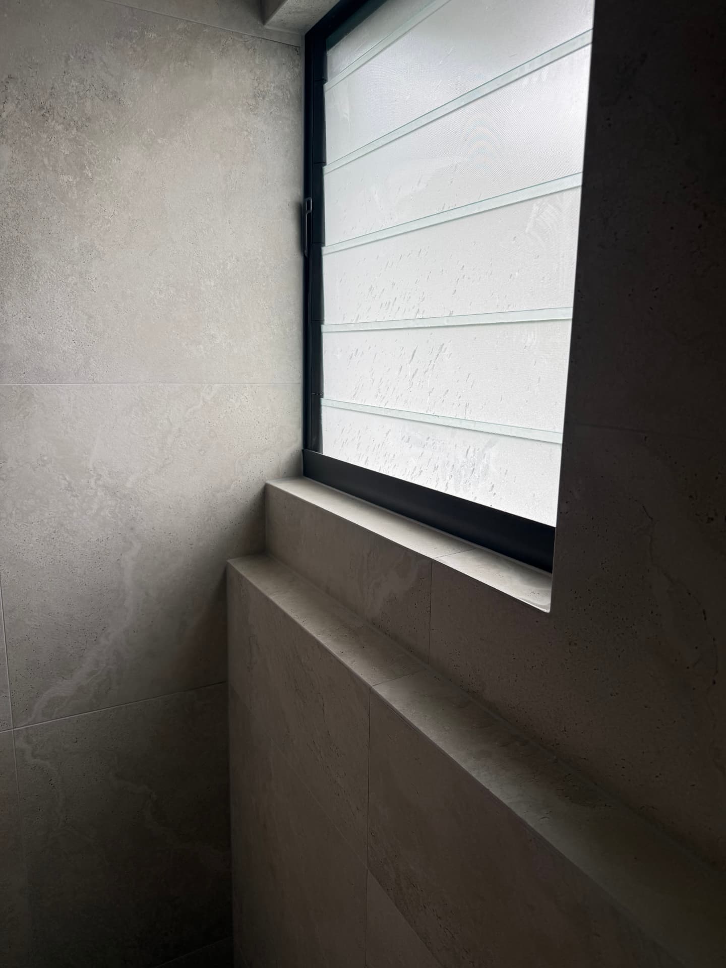 Tiled window bench viewed on an angle in a new bathroom