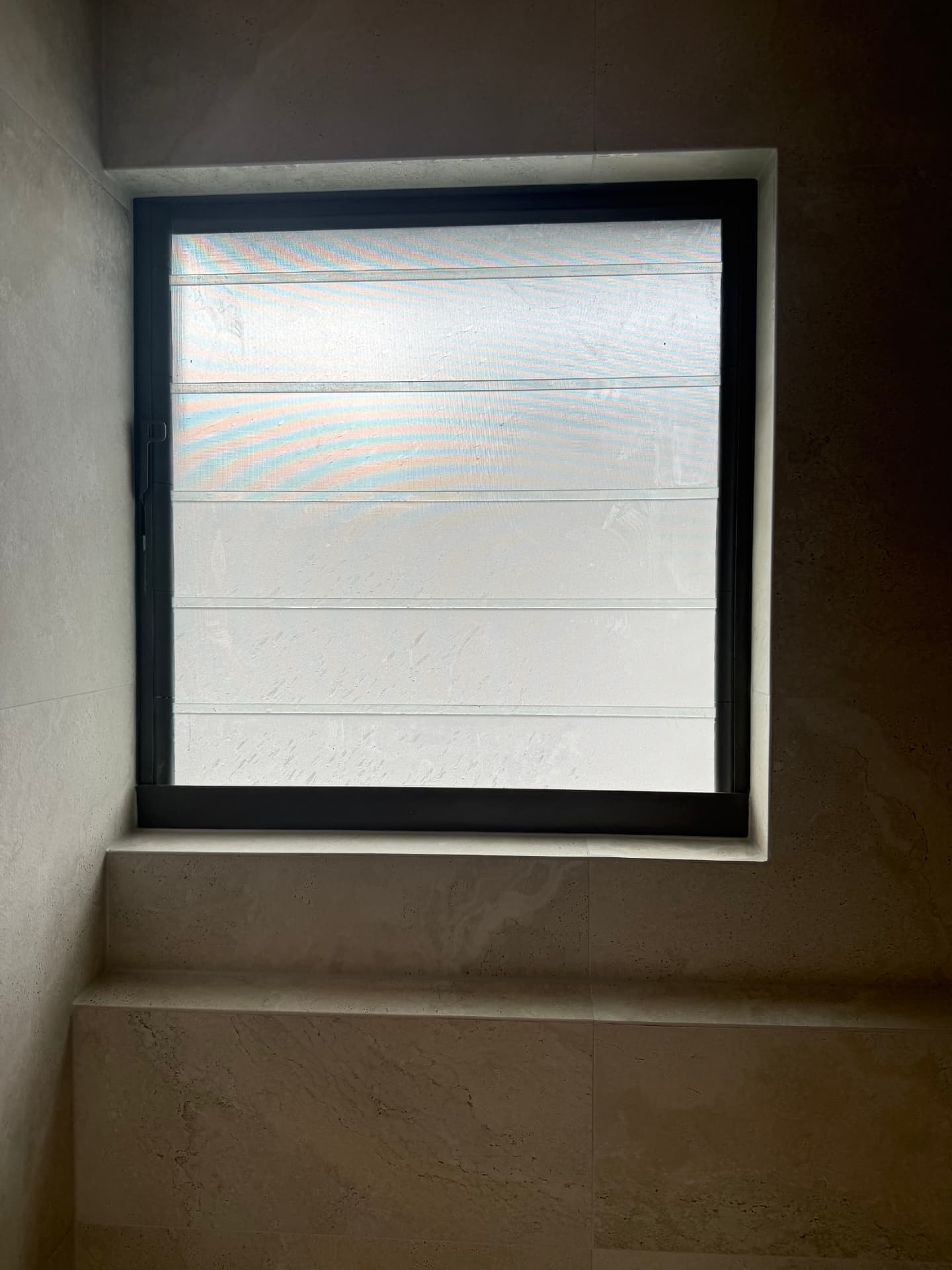 Newly tiled bathroom wall with a window bench and clean tile joints